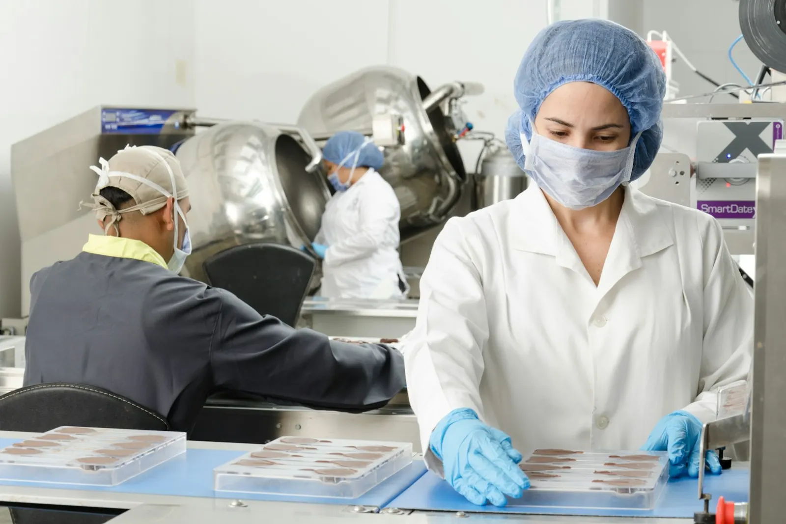 Opératrice en charlotte, masque et gants dans un atelier de transformation alimentaire, application de la méthode HACCP